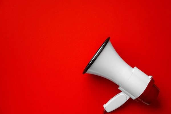 Electronic megaphone close up on red background Oportunidades